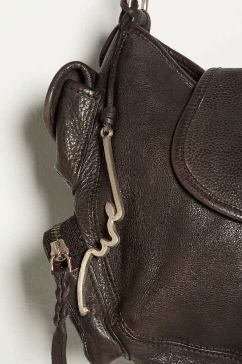 Close-up of a brown leather bag with a carabiner on a white background