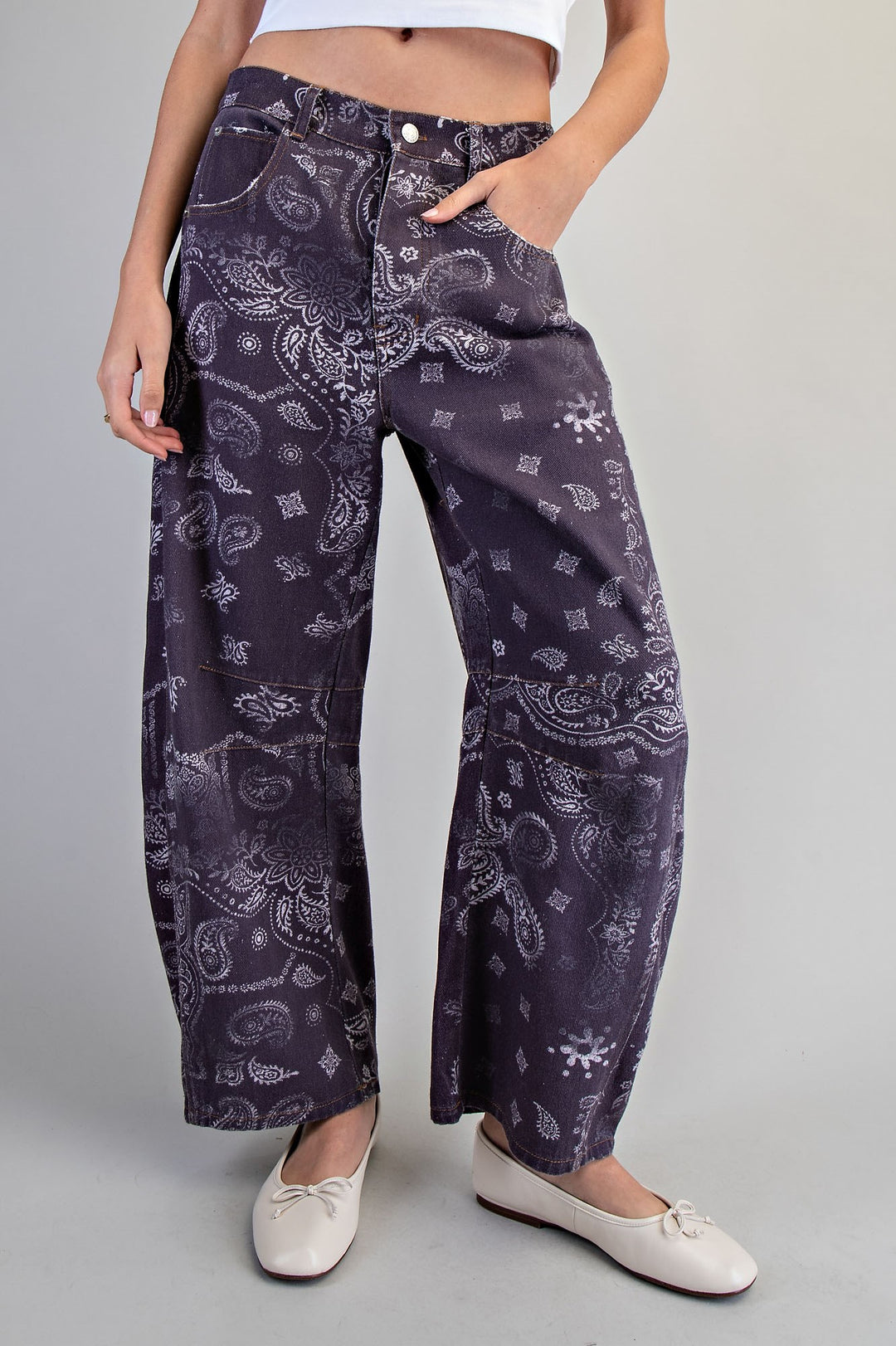Person wearing purple paisley patterned pants on a plain background