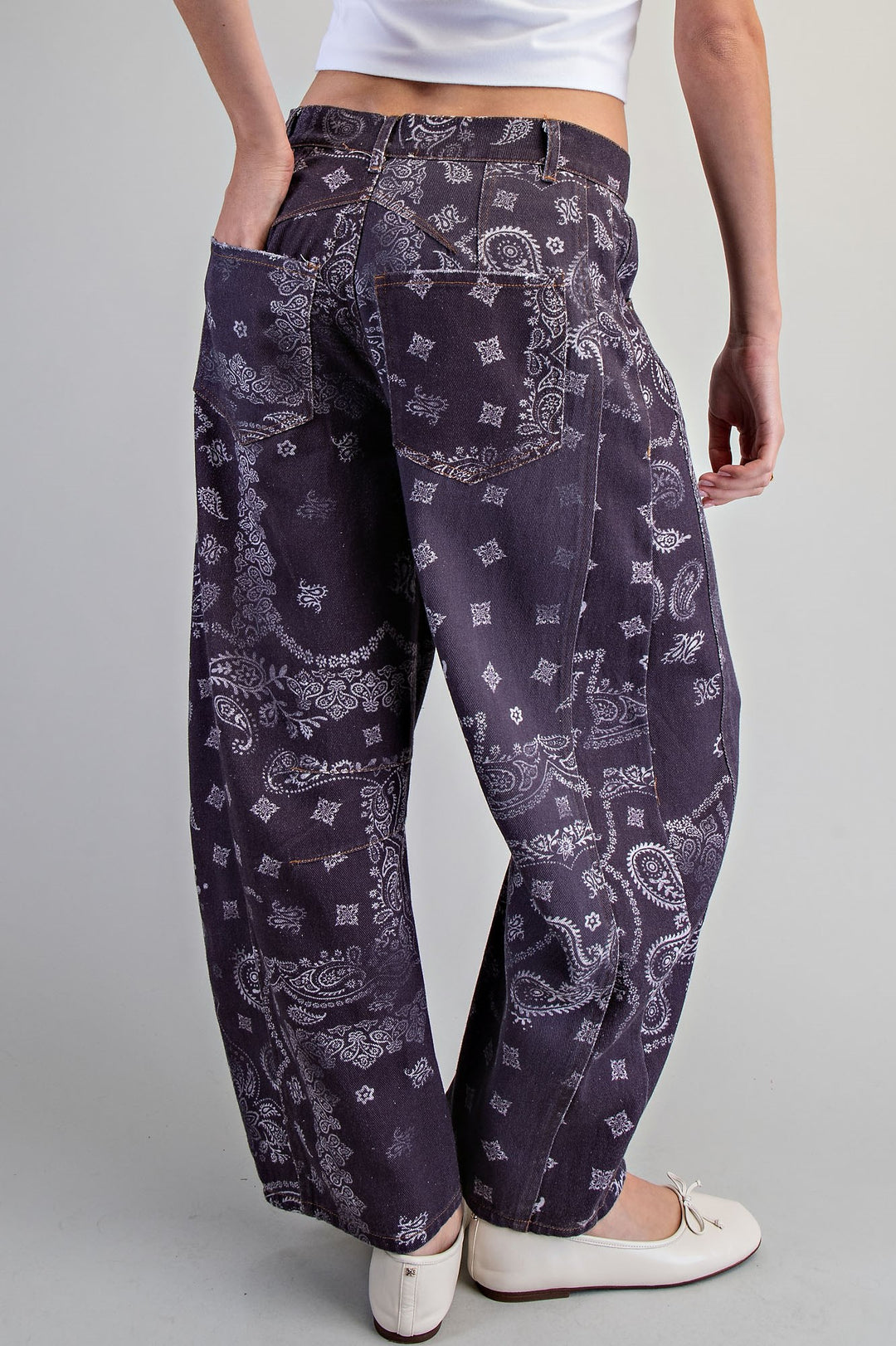 Person wearing dark purple patterned pants on a gray background