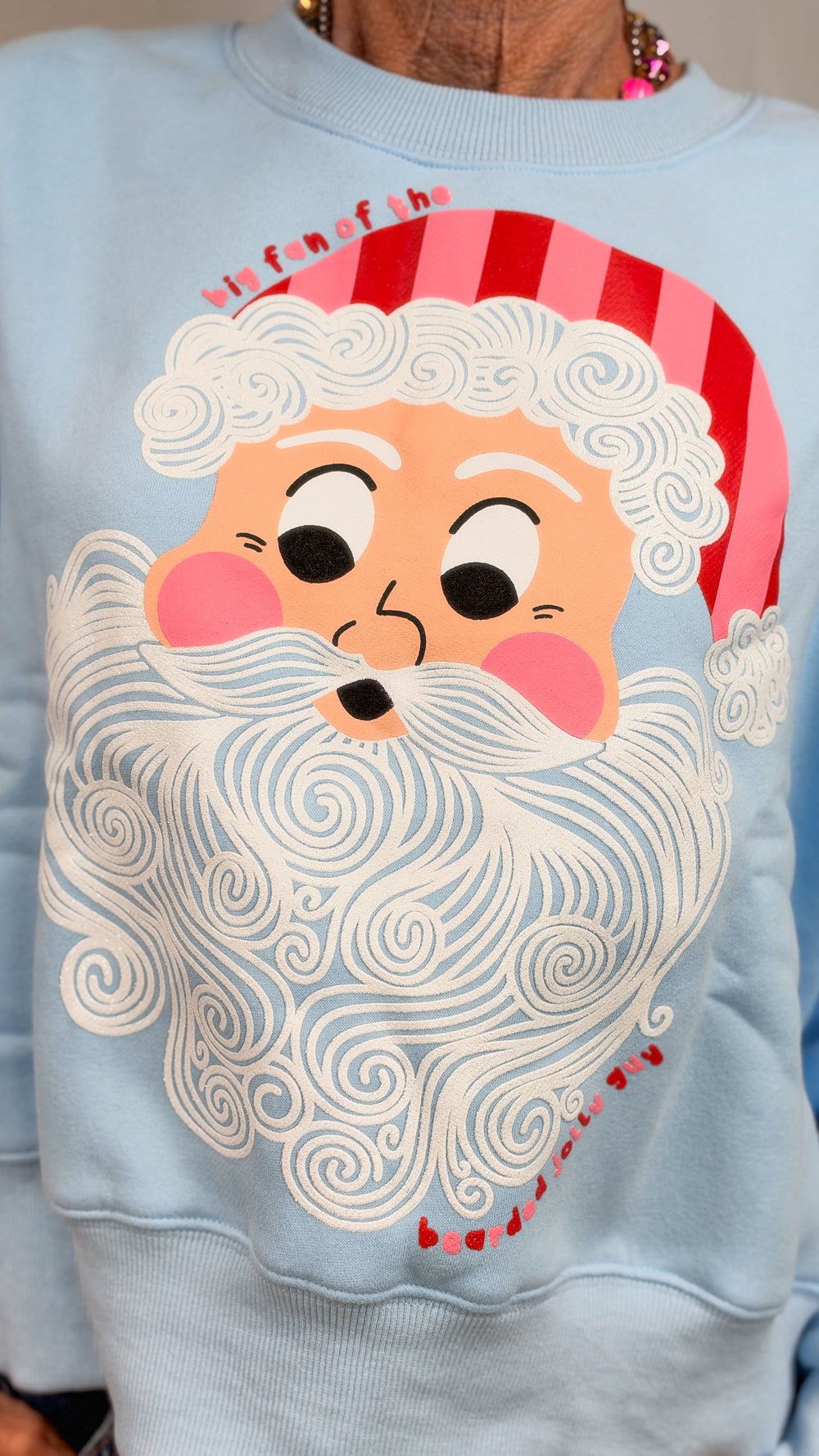 Close up of light blue sweatshirt with vintage santa face and 'big fan of the bearded jolly guy' 