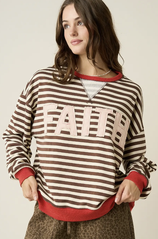 Woman wearing brown and white stripe top with &