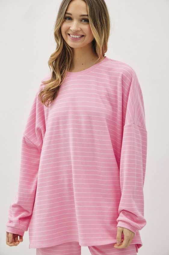 Woman wearing matching pink top and bottom on plain background