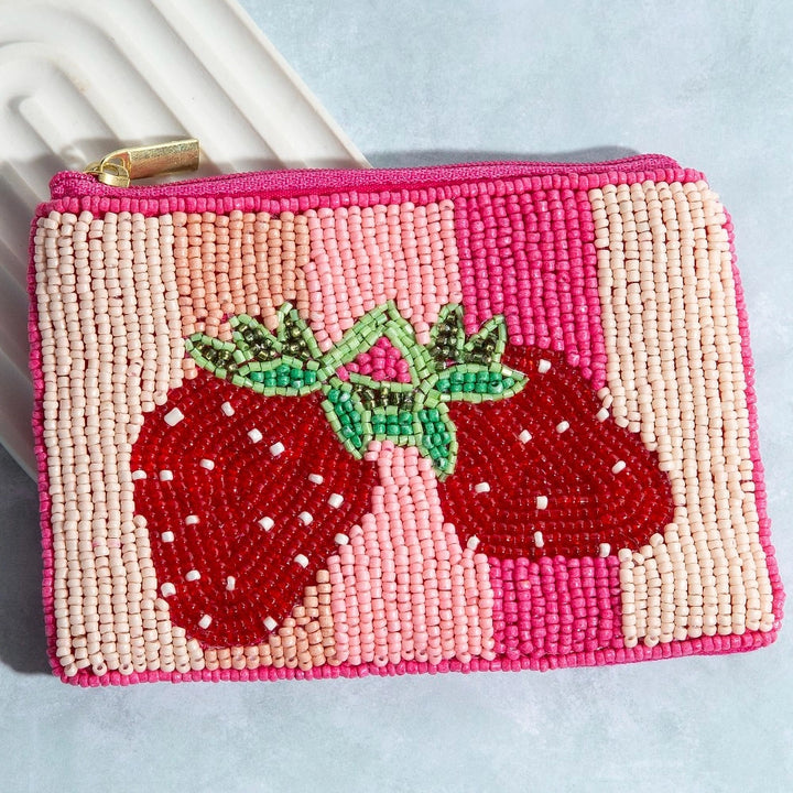 Beaded pouch with strawberry design on a light blue background