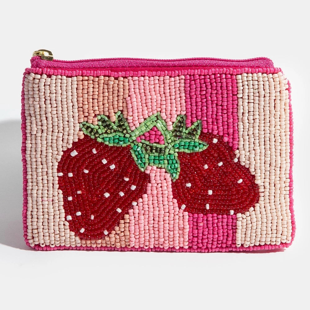 pink beaded coin purse with strawberries on plain background