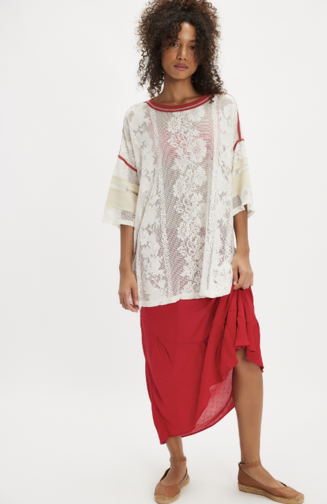 Woman wearing a white lace top and red skirt on a white background