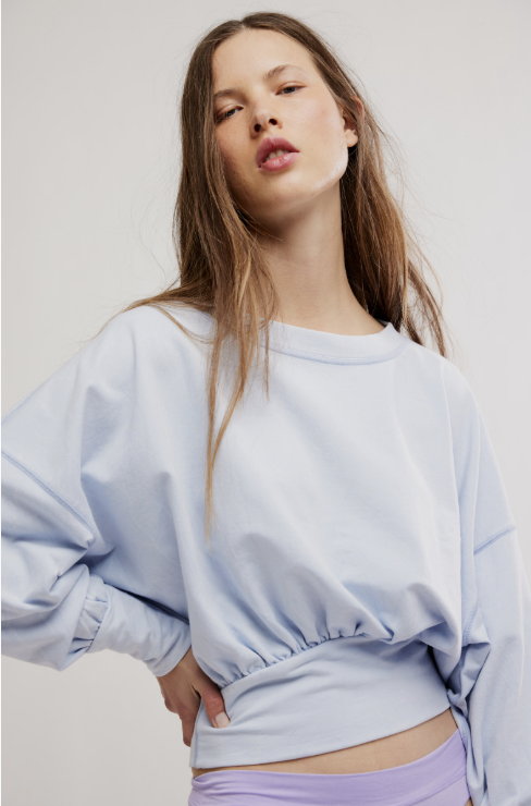 Woman wearing light blue sweatshirt on white background