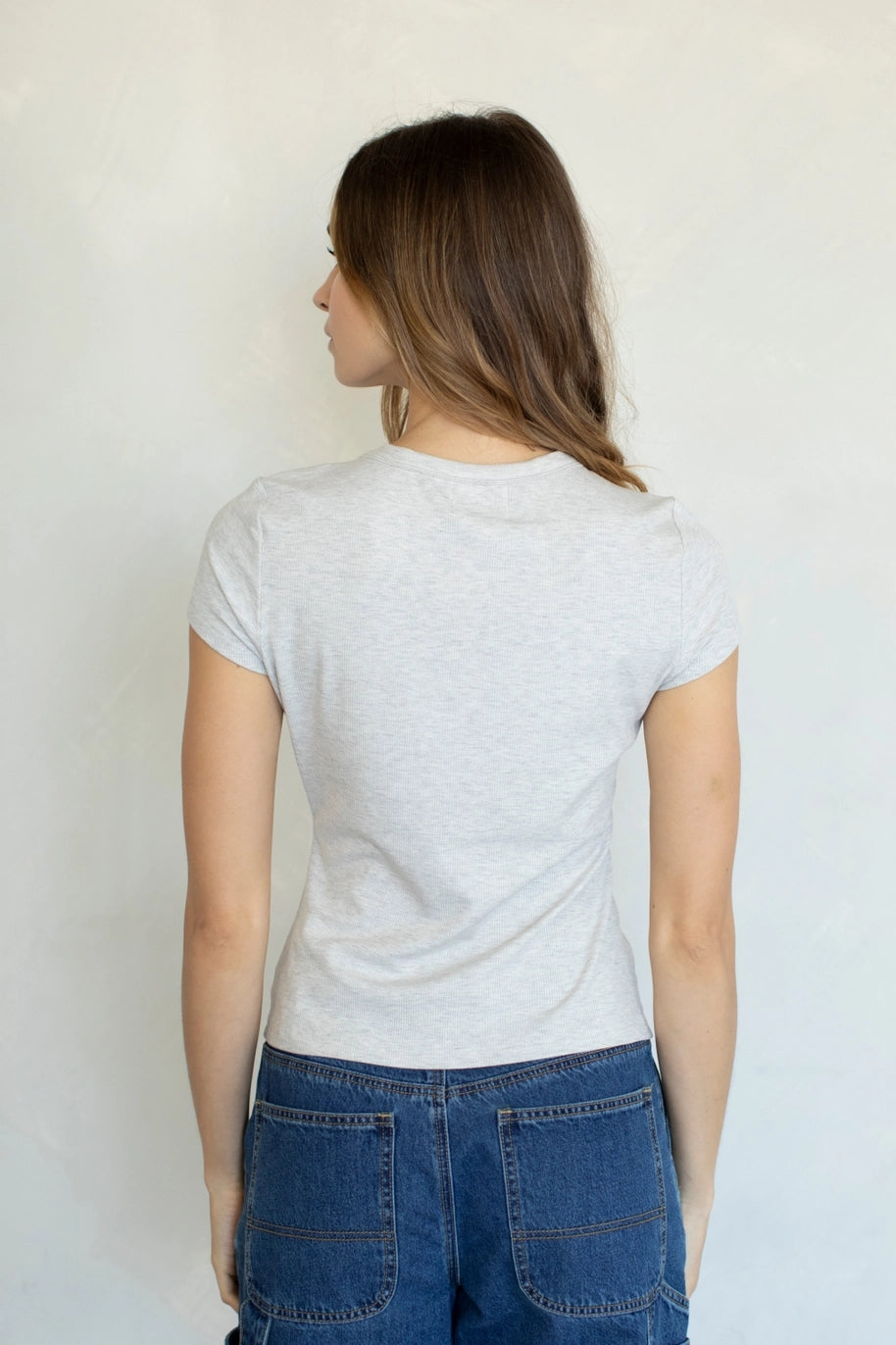 Back of woman wearing heather grey tee on plain background