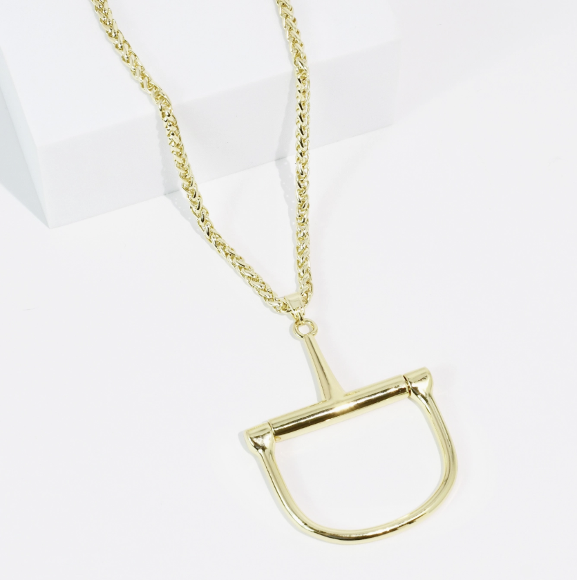 Gold horse bit necklace on white background