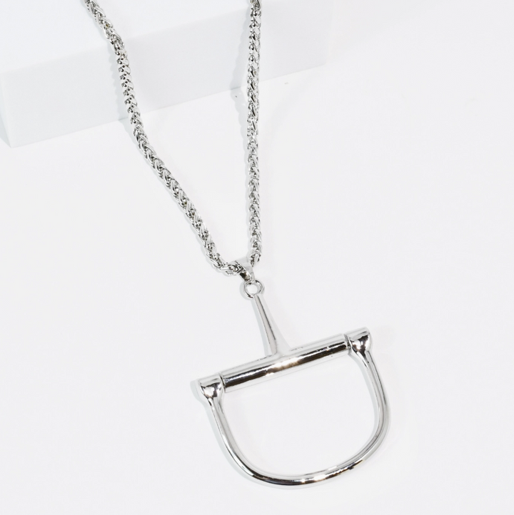 A silver-toned metal necklace featuring a horse bit pendant, displayed on a clean white background.