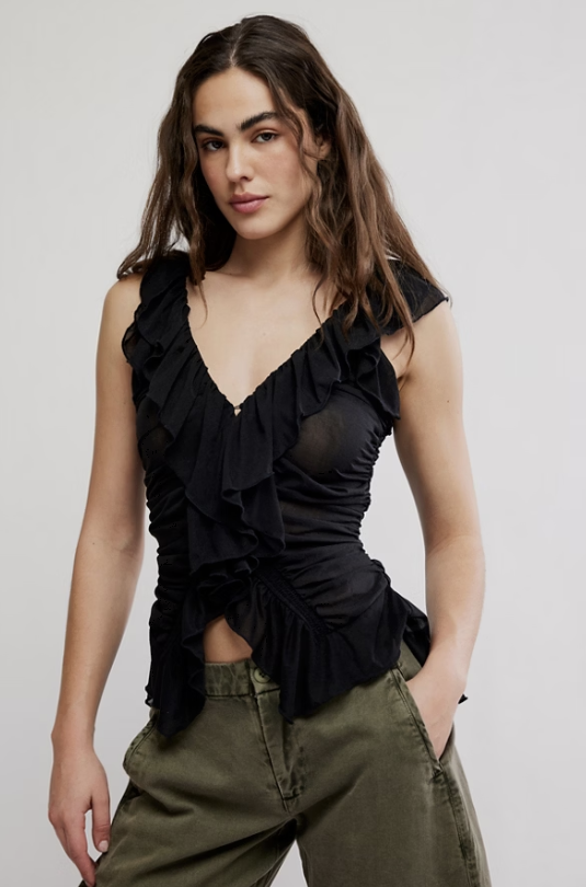 Woman wearing black shirt and green pants on white background