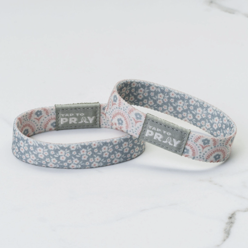 Two floral-patterned wristbands with 'Tap to Pray' text on a white background