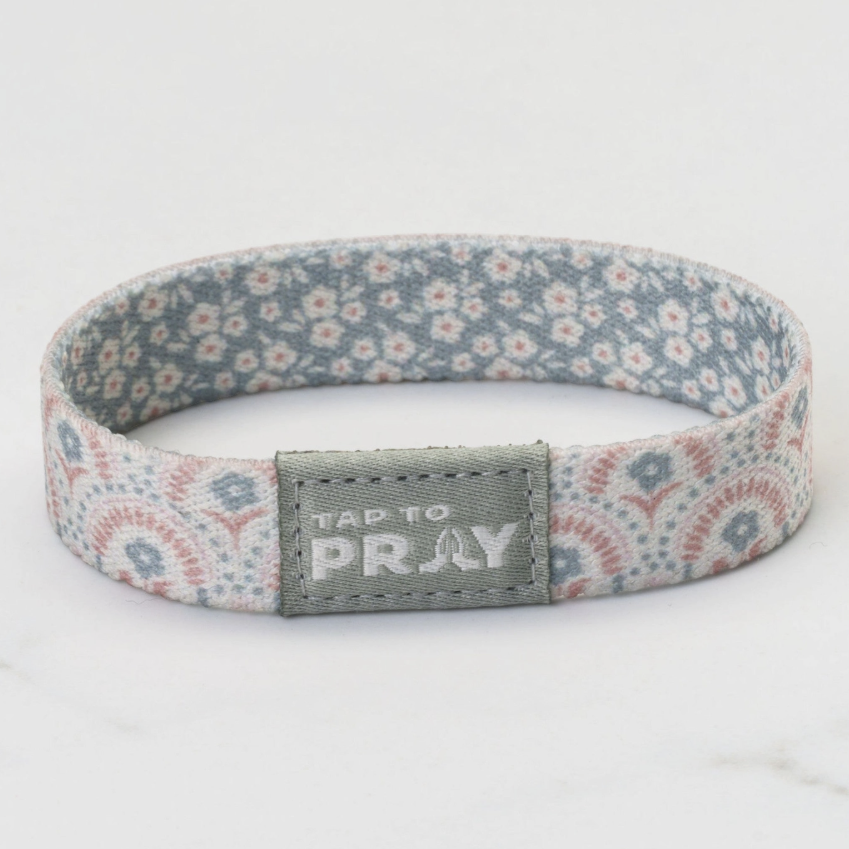 Floral patterned headband with 'Tap to Pray' tag on a white background