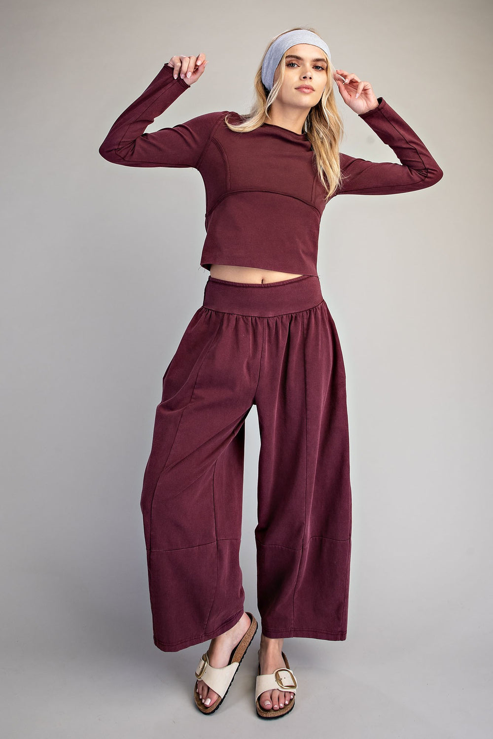 Woman wearing matching lounge set in red bean colorway on plain background