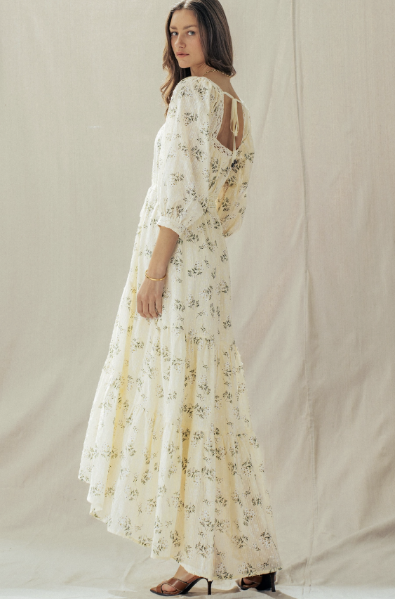 Woman wearing a floral dress against a plain background