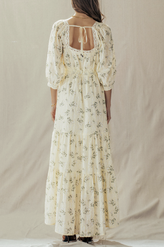 Woman wearing a floral dress against a plain background