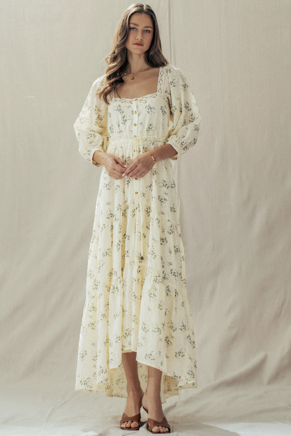 Woman wearing a floral dress against a plain background