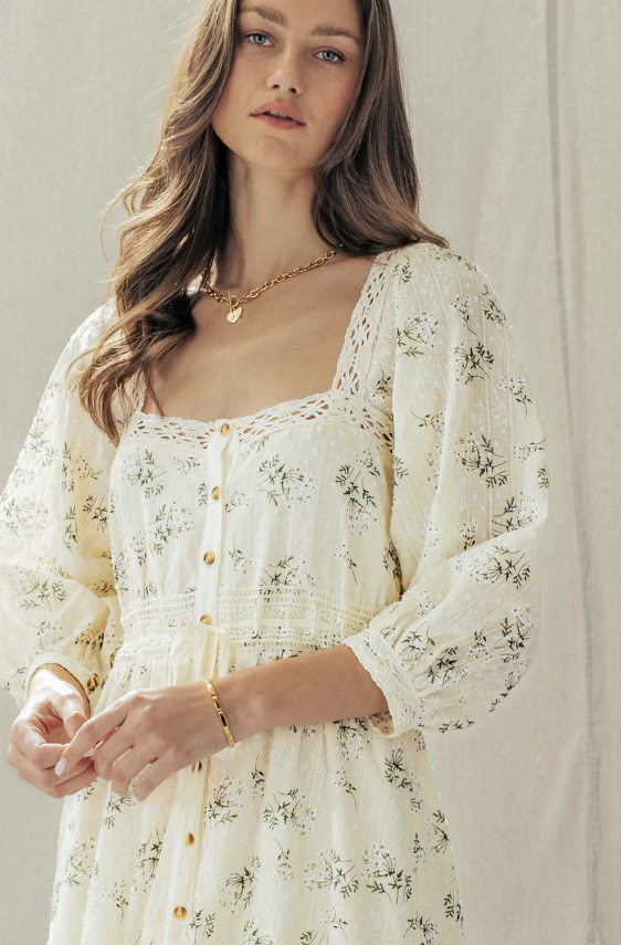 Woman wearing a white floral dress with a neutral background