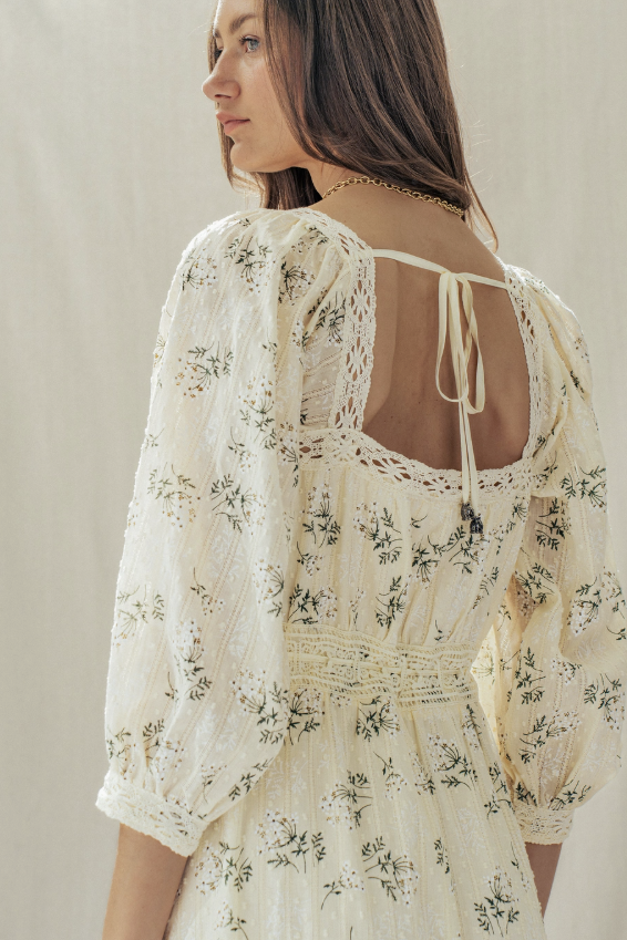 Woman wearing a floral dress with a neutral background