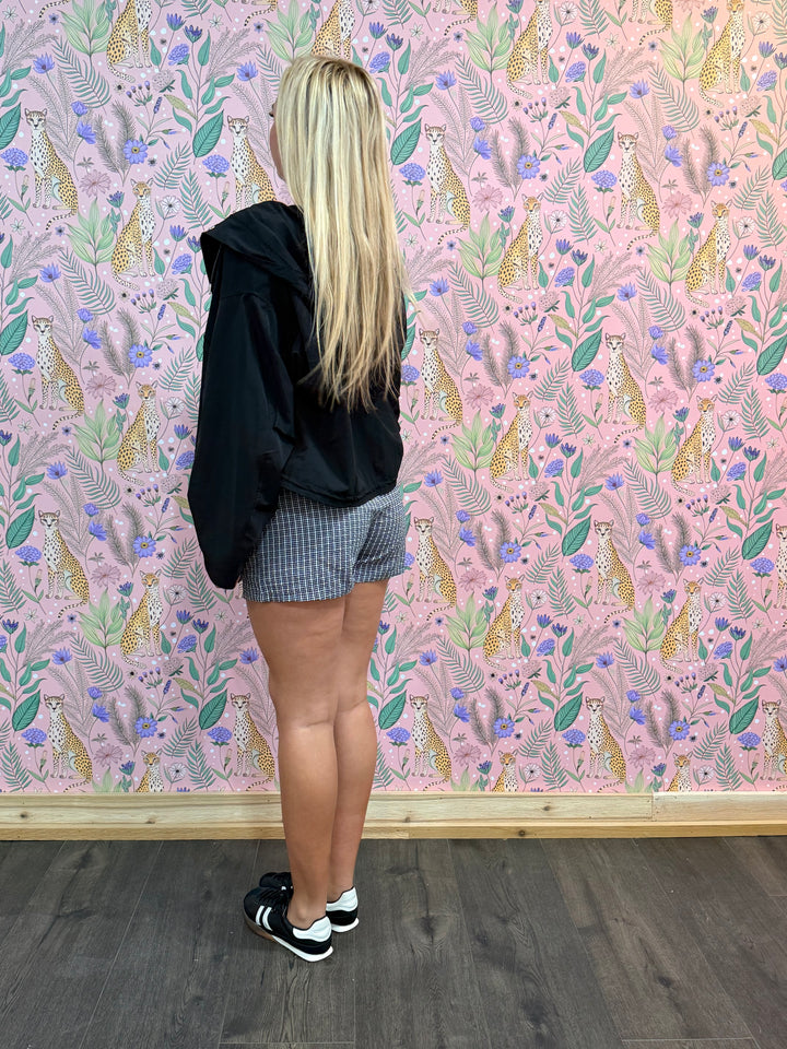 Person standing in front of a wall with a colorful animal pattern