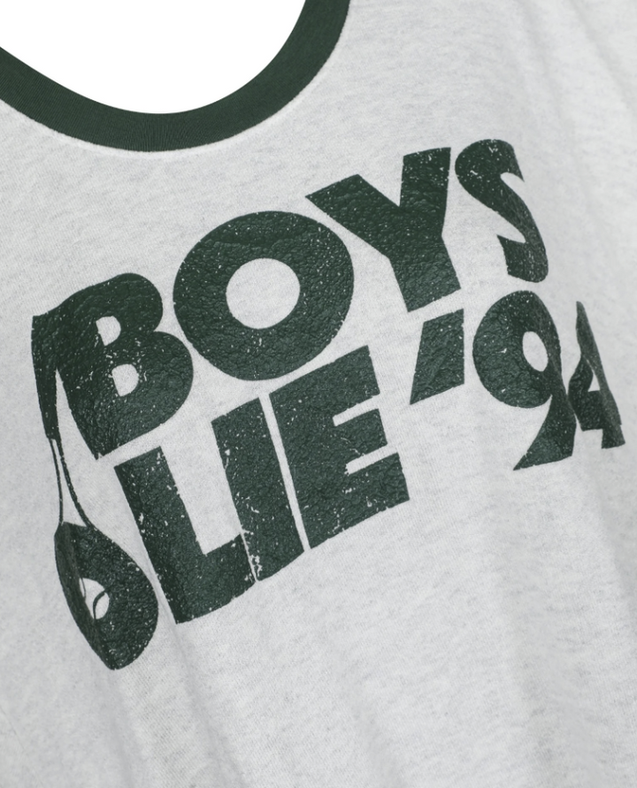 Close-up of a light heather gray t-shirt featuring a distressed dark green graphic print that reads &