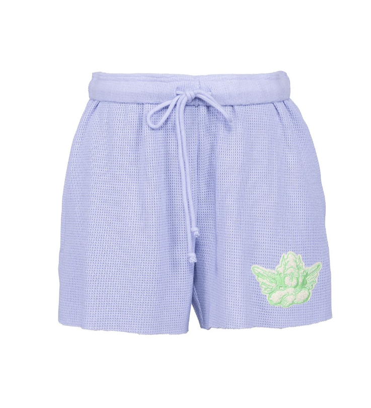 Light purple waffle-knit shorts with a matching drawstring waist and a green angel graphic on the lower left leg, shown against a plain white background.