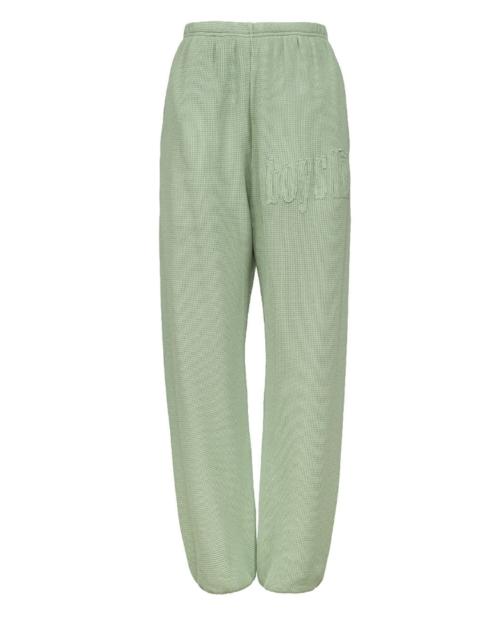 Light sage green sweatpants with a subtle wavy pattern and an embroidered &