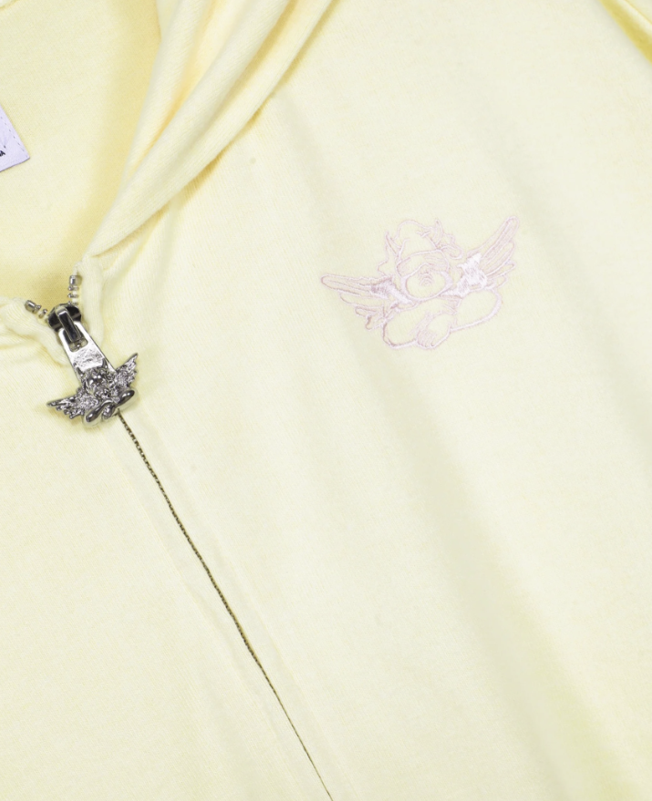 Close-up of a yellow fabric with decorative elements on a light yellow background