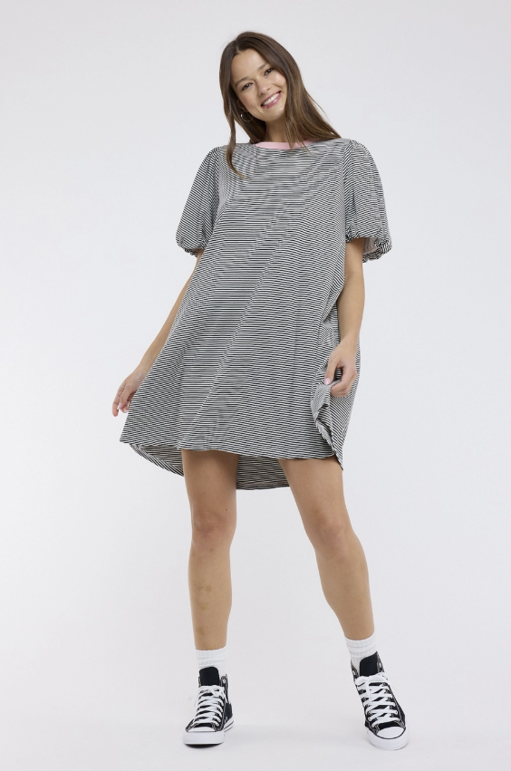 Woman wearing a gray and white striped dress on a white background