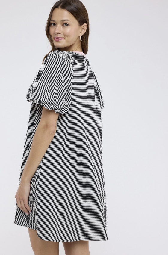 Woman wearing a black and white striped dress on a white background