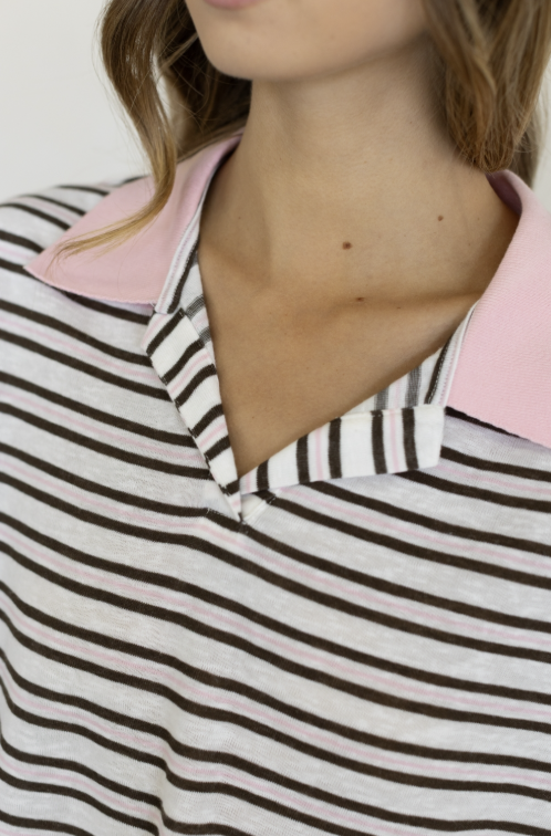 Close up of woman wearing brown and pink stripe collared shirt on plain background