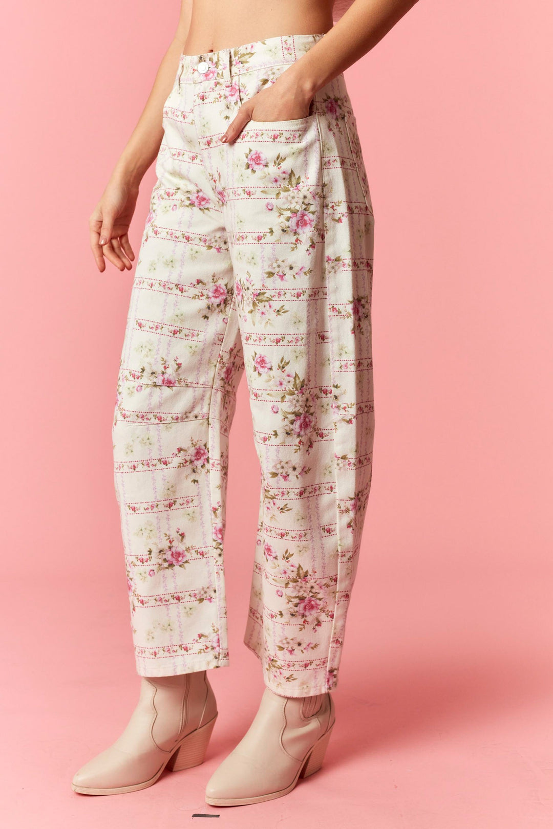 Floral patterned pants worn by a person on a pink background