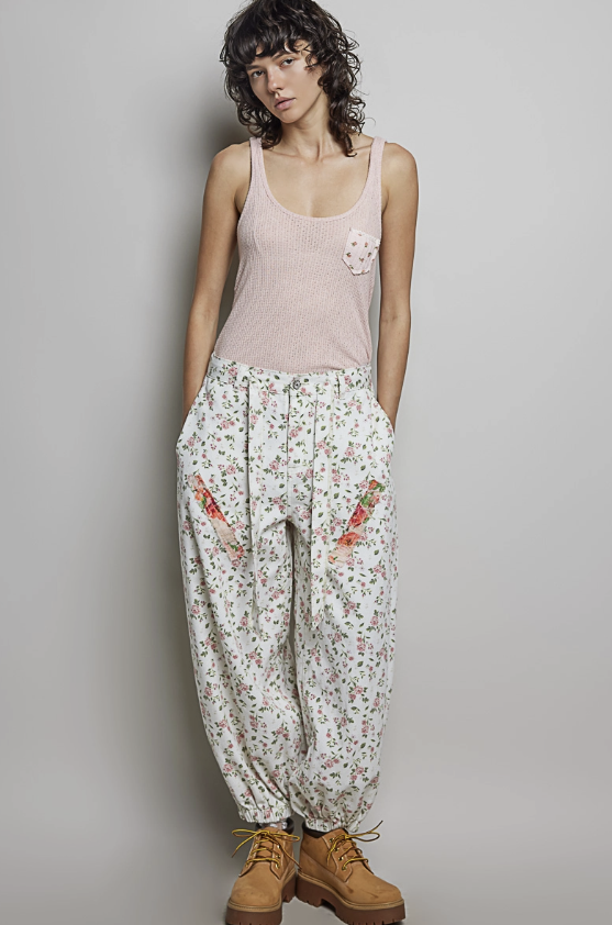 Woman wearing balloon pants and pink tank on plain background