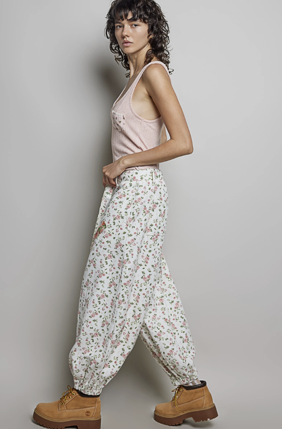 Woman wearing balloon pants and pink tank on plain background