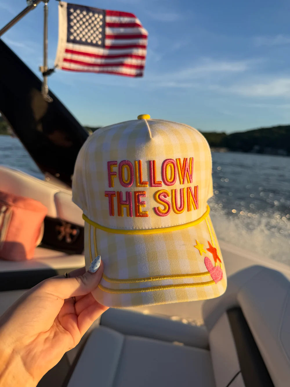 Hand holding hat embroidered with &