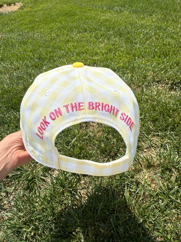 Hand holding hat embroidered with &
