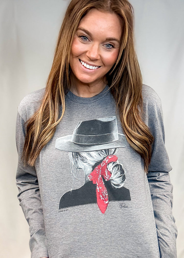 Woman wearing long sleeve grey graphic tee with woman wearing hat and bandana in her hair on white background