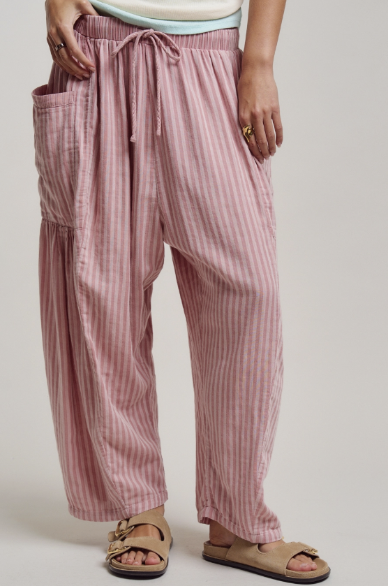 Pink striped pants worn by a person on a plain background