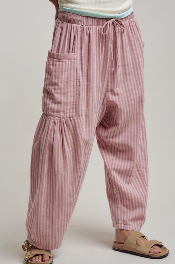 Pink striped pants worn by a person on a plain background
