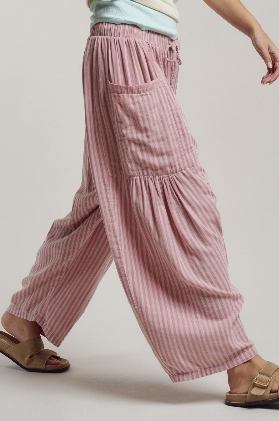 Pink striped pants worn by a person on a plain background