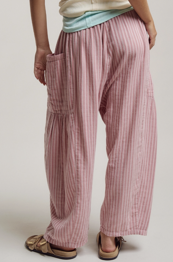 Person wearing pink striped pants on a plain background