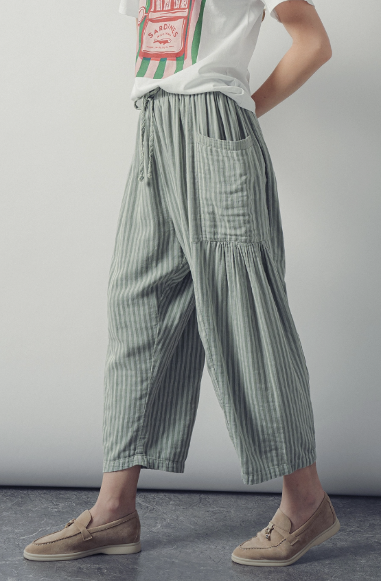 Person wearing green striped pants with a plain background