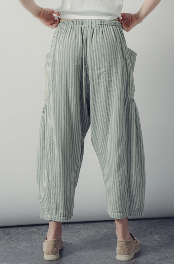 Person wearing green striped pants against a plain background