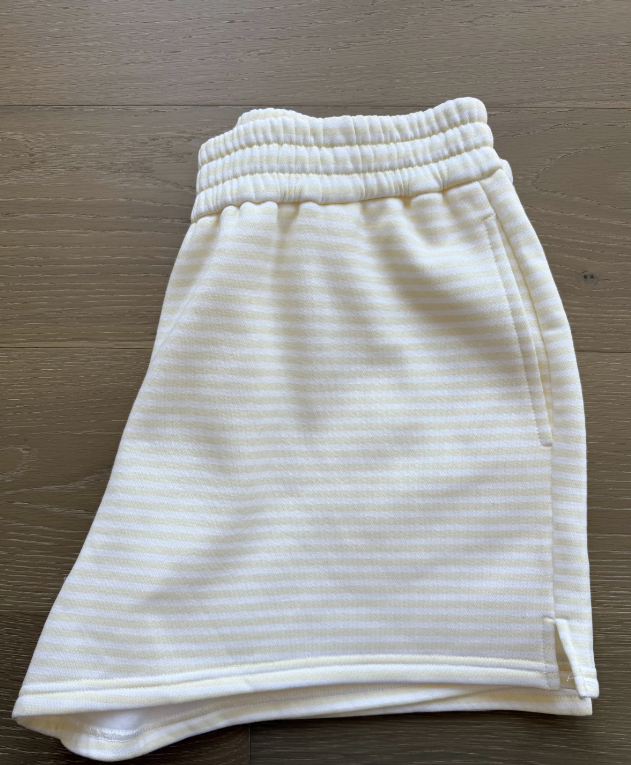 Yellow and white stripe shorts laying on wood floor