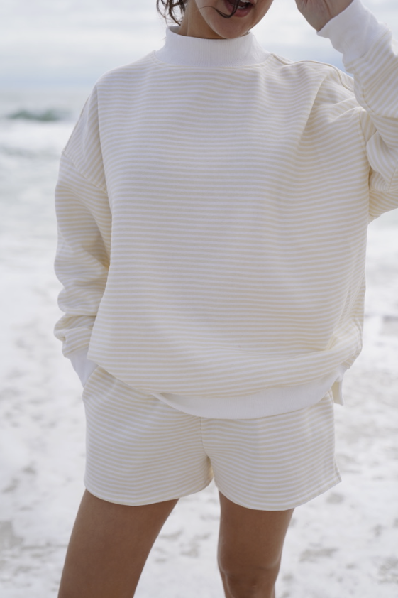 Woman wearing matching yellow striped set on beach
