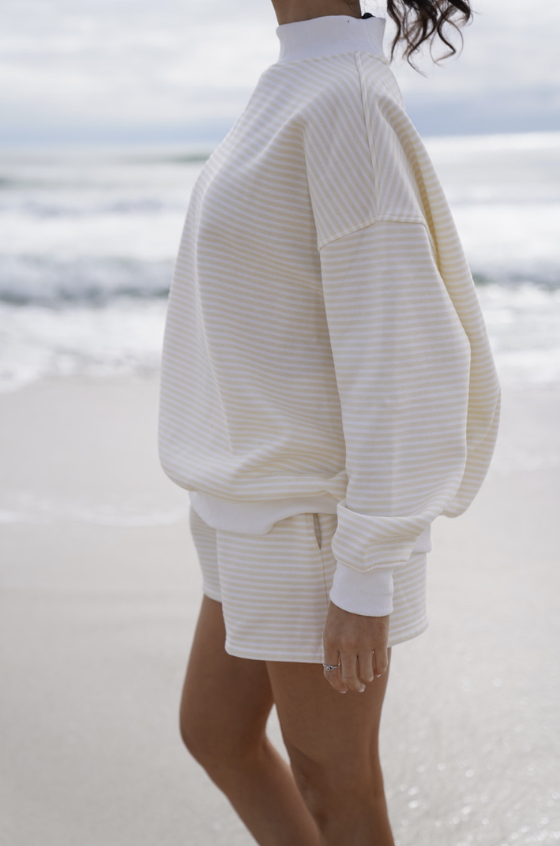 Woman wearing matching yellow stripe set on the beach
