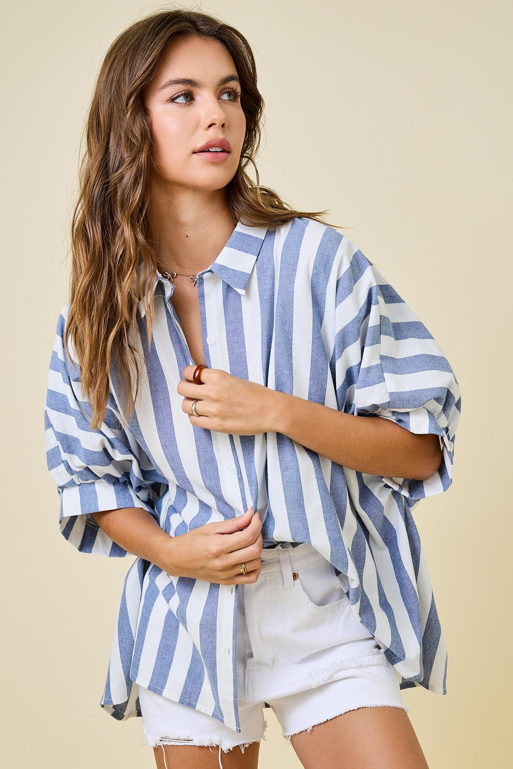 Woman wearing a blue and white striped shirt with a beige background