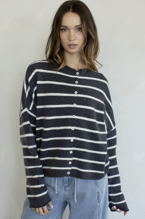 Woman wearing grey and white stripe cardigan on plain background