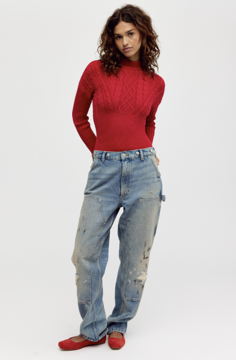 Woman wearing red mock neck bodysuit and light denim jeans on white background