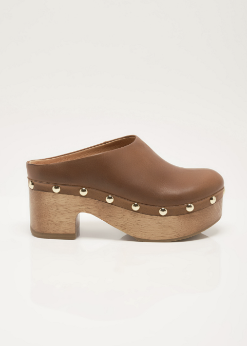 A single brown leather clog shoe with a wooden platform and block heel, decorated with small gold-tone metal studs, shown in a side profile on a white background.