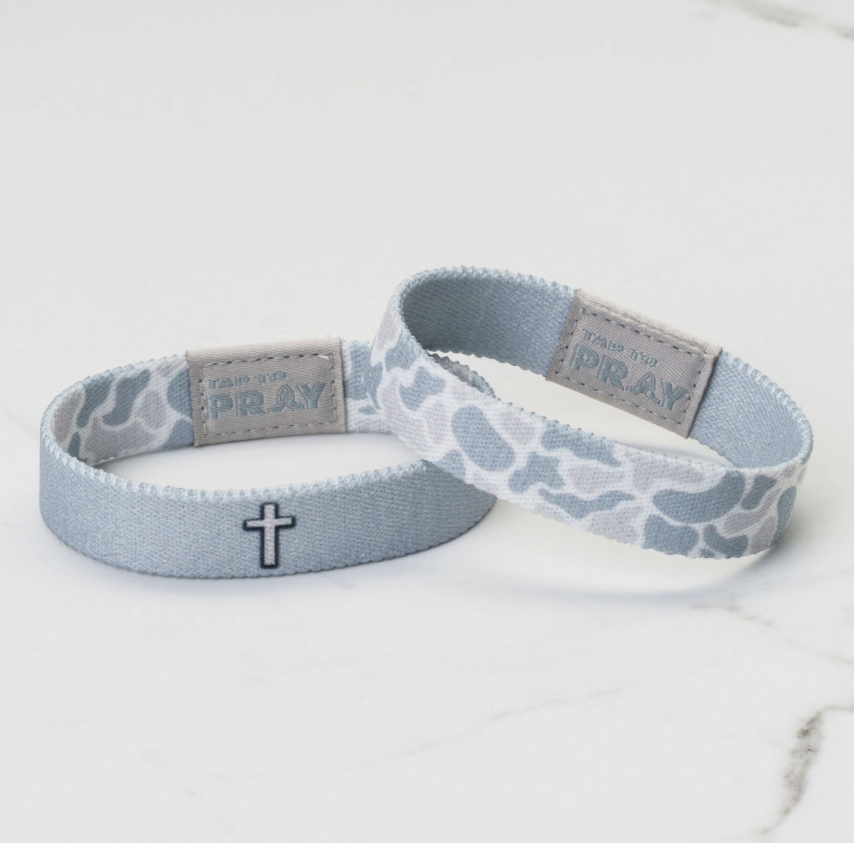Two fabric bracelets with cross designs on a light background